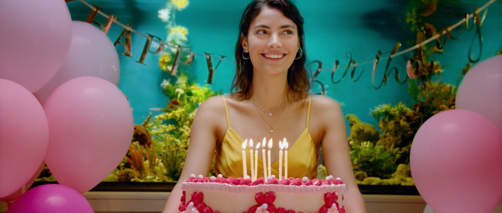 a woman blowing candles on a birthday cake
